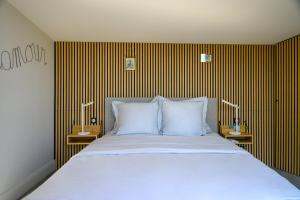ein Schlafzimmer mit einem großen Bett mit zwei Nachttischen in der Unterkunft Maison-M AIX in Meyreuil