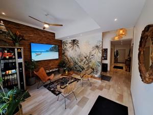 a living room with a tv on a brick wall at Residence Veles Plage in Cannes