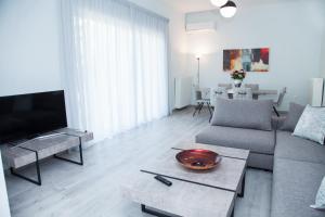 a living room with a couch and a tv at Sunny and minimal apt in Glyfada with 3 bdrm in Athens