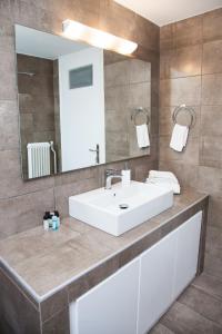 a bathroom with a white sink and a mirror at Sunny and minimal apt in Glyfada with 3 bdrm in Athens