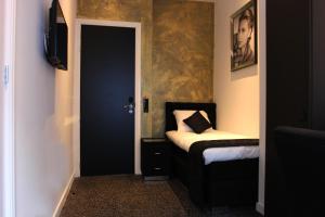 a room with a bedroom with a bed and a tv at Sara's Boutique Hotel in Amsterdam