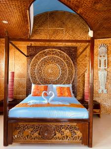 a bedroom with a bed with an ornate head board at Casa de Arte in Boracay