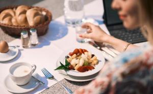 een vrouw aan een tafel met een bord eten bij EurothermenResort Bad Hall - Hotel Miraverde in Bad Hall