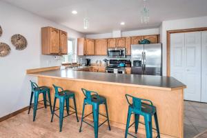 a kitchen with a counter with four stools around it at Canal-Front Vacation Rental in Ocean Shores in Ocean Shores