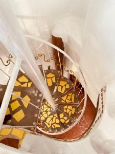 a spiral staircase with yellow and brown tiles at Casa de Arte in Boracay