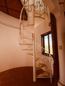 a spiral staircase in a house with a window at Casa de Arte in Boracay