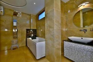 a bathroom with a sink and a tub and a toilet at Dalhousie valley Resort By DLS Hotels in Banikhet +31 photos