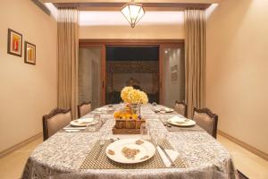 a dining room table with a table cloth and flowers on it at Ekant Villa with Pvt Pool at Amritsar by StayVista in Amritsar