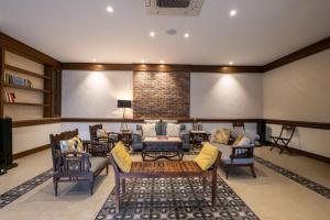 a living room with couches and chairs and a tv at Stay Vista at Ekant Villa - 3BR in Amritsar