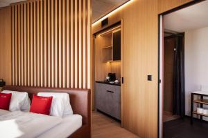 a bedroom with a bed with red pillows at Tailormade Hotel RIGIBLICK Küssnacht in Küssnacht