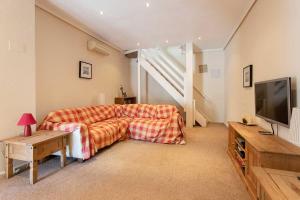 a living room with a couch and a flat screen tv at CH Villa Golf Park La Marquesa in Rojales