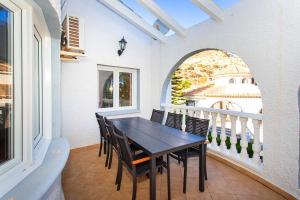 a dining room with a table and chairs on a balcony at CH Villa Golf Park La Marquesa in Rojales
