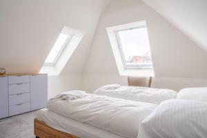 twee bedden in een witte kamer met twee ramen bij Haus Badestrand Badestrand 3 in Born