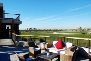 une terrasse avec un canapé et des chaises ainsi qu'un parcours de golf dans l'établissement El Oasis de las Palmeras @ Roda Golf & Beach resort, à San Javier