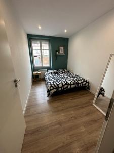 een slaapkamer met een bed in de hoek van een kamer bij # Le 2 # Très Beau T3 1er étage tout confort, neuf, Mulhouse centre in Mulhouse