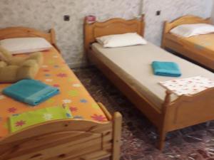 two twin beds in a room with a teddy bear at Antonioy Apartment in Diáva