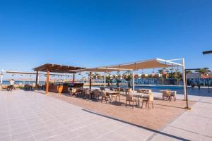 a patio with tables and chairs next to a pool at You are welcome to Mido Shallet in Naqādah
