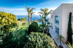 an aerial view of a house with palm trees and the ocean at Beautiful Villa with amazing Monte Carlo & Sea View in La Turbie