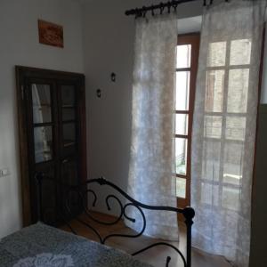 a bedroom with a bed and a window with curtains at Da Linda in Guinadi