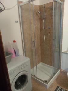a shower in a bathroom with a washing machine at Da Linda in Guinadi