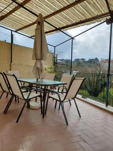 a table and chairs with a umbrella on a patio at Casa Gargiulo in Massa Lubrense