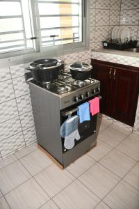 cocina con fogones, 2 ollas y sartenes en Spetiv Guesthouse en Douala