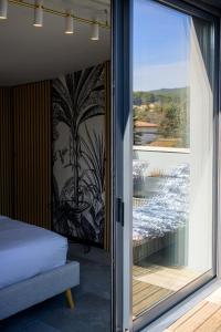 1 dormitorio con una puerta corredera de cristal que da a un balcón en Maison-M AIX, en Meyreuil