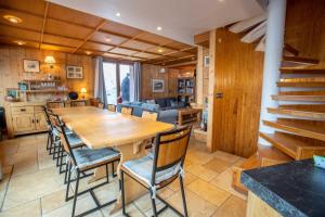 a kitchen and dining room with a wooden table and chairs at Chalet Clearmount with Spa in Méribel