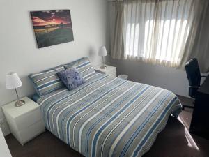 1 dormitorio con 1 cama con edredón azul y blanco en 2 Beds 2 Baths Apt In Braddon CBD - Pool, 1 Free Parking, Gym, en Canberra