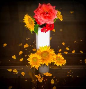 a white vase filled with yellow and red flowers at Misty Hills Villa Kadugannawa in Kadugannawa