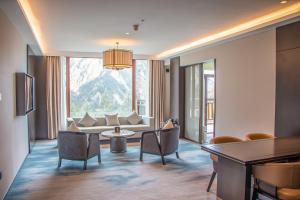 sala de estar con sofá, mesa y sillas en InterContinental Resort Jiuzhai Paradise, an IHG Hotel en Jiuzhaigou