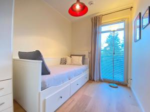 ein Schlafzimmer mit einem Bett und einem großen Fenster in der Unterkunft Residenz Bleichröder - Ferienwohnung 16 in Heringsdorf