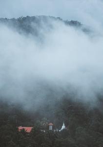 a misty mountain with a house in the middle at Misty Hills Villa Kadugannawa in Kadugannawa