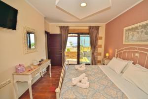 a bedroom with a bed and a desk with towels on it at Villa Archontissa in Análipsis