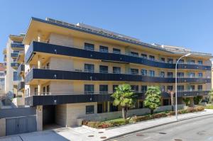 un immeuble avec balcons bleus dans une rue dans l'établissement FLATSELECT Pinamar, à Sanxenxo