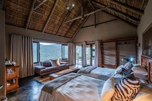 a bedroom with two beds and a large window at Huntshoek Lodge in Grahamstown