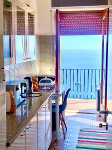 a kitchen with a table and a view of the ocean at Maison belle Vue in Taormina