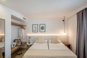 a bedroom with a large white bed in a room at Apartamentos Top Secret Prestige Es Pujols - Formentera Vacaciones in Es Pujols