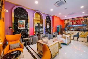 um restaurante com paredes e cadeiras cor de laranja e roxo em Mekong Heritage Hotel em Nakhon Phanom