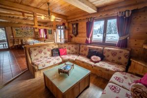 salon z kanapą i stołem w obiekcie Les Griottes, véritable chalet de montagne, avec Jacuzzi et Sauna w mieście Xonrupt-Longemer