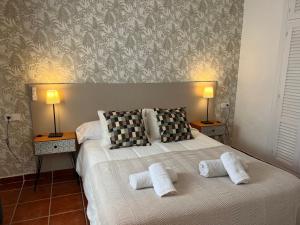 a bedroom with a bed with two pillows and two lamps at PUERTO BANUS POL One in Marbella