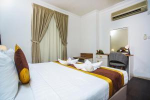 una camera d'albergo con un letto, una scrivania e uno specchio di La Villa Suites Hotel a Doha