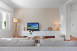 sala de estar con sofá, sillas y TV en Casa Mosa, en Marbella