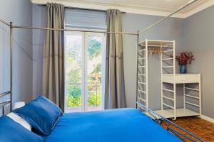 Un dormitorio con una cama azul y una ventana en Villa Caramino en Fara Novarese