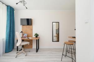 a room with a desk and chairs and a mirror at Studio Cracow Rakowicka 14 by Renters in Krakow