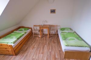two beds in a room with a table and chairs at Ubytovna Toulcův dvůr in Prague