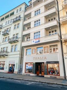 un edificio en una calle de la ciudad con una tienda en Apartments Thalia, en Karlovy Vary