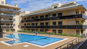 a swimming pool in front of a building at FLATSELECT Pinamar in Sanxenxo