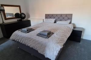 Large 4 bed (sleeps 8) Castle View في إدنبرة: غرفة نوم بها سرير كبير مع مناشف عليه