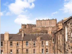 Large 4 bed (sleeps 8) Castle View في إدنبرة: مبنى قديم مع قلعة في الخلفية
